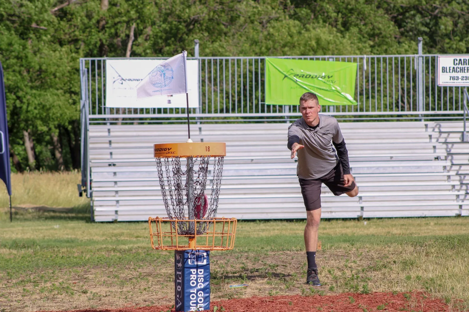 Pelaaja heittää kiekon frisbeegolfkoriin