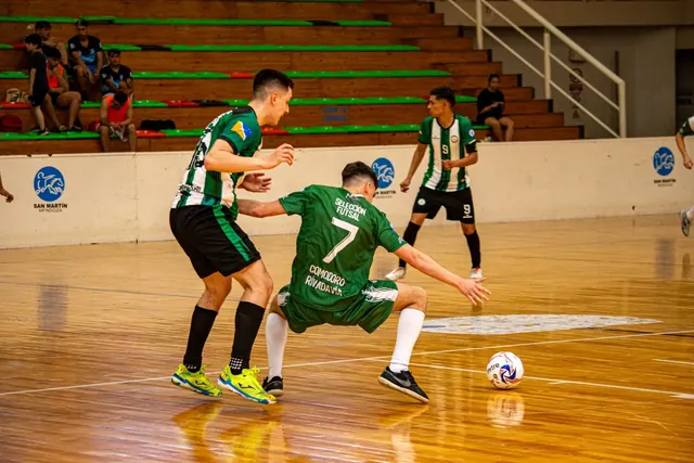 Pelaajat kamppailevat pallosta futsal-ottelussa sisähallissa