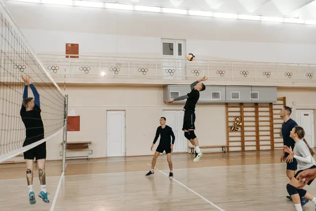 Pelaaja hyppää lyömään pallon verkon yli lentopallo-ottelussa