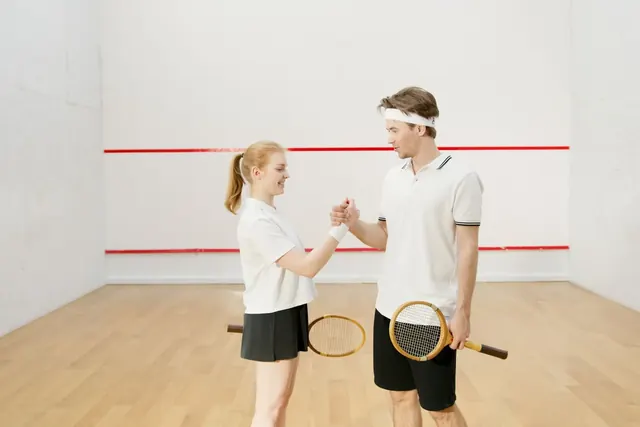 Kaksi squash-pelaajaa kättelee kentällä ennen peliä