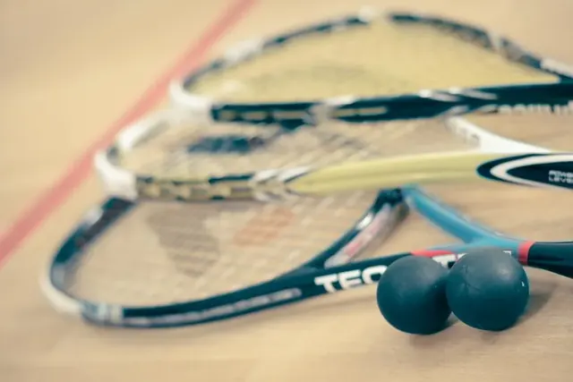 Squashmailoja ja kaksi squashpalloa lattialla