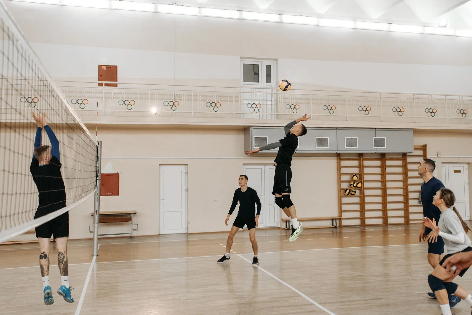 Pelaaja hyppää lyömään pallon verkon yli lentopallo-ottelussa