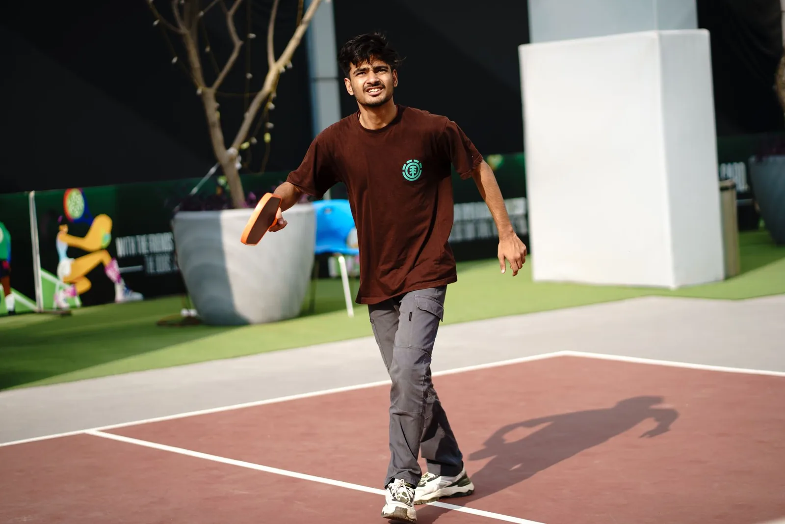 Pelaaja liikkuu pickleball-kentällä maila kädessä